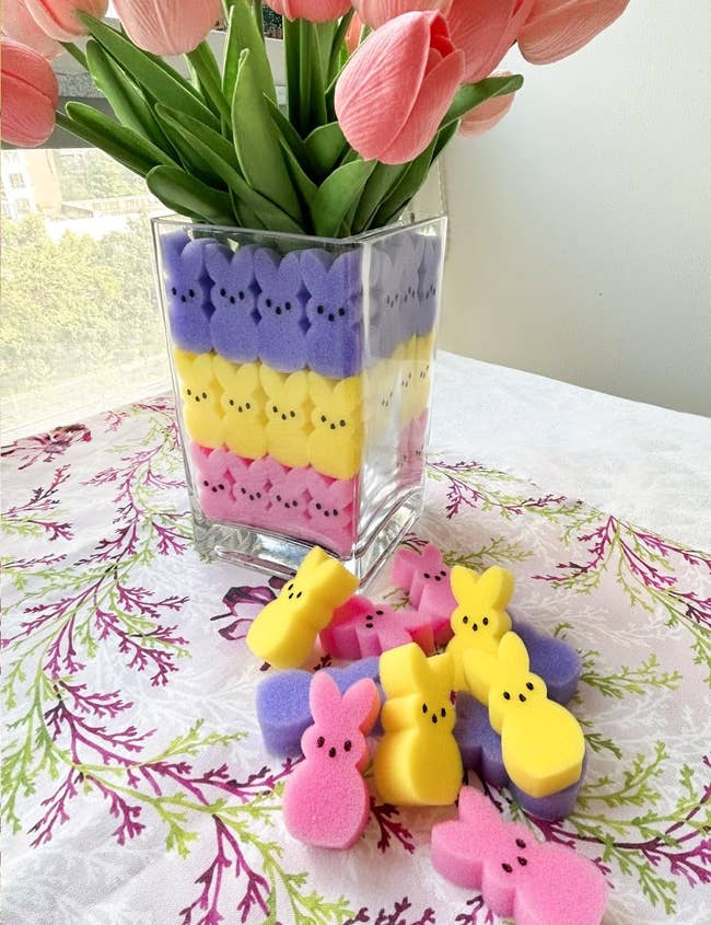 a reviewer's flower vase filled with the Peeps sponges and pink tulips with more sponges laying in front of it