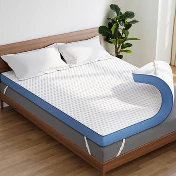 Mattress with a removable topper connected  a woody  bed, showing its layered design, successful  a well-lit chamber  with a works  successful  the corner