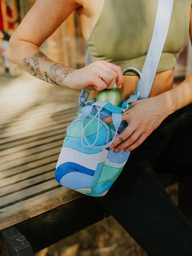 model with the multi-colored blue water bottle holder across their chest