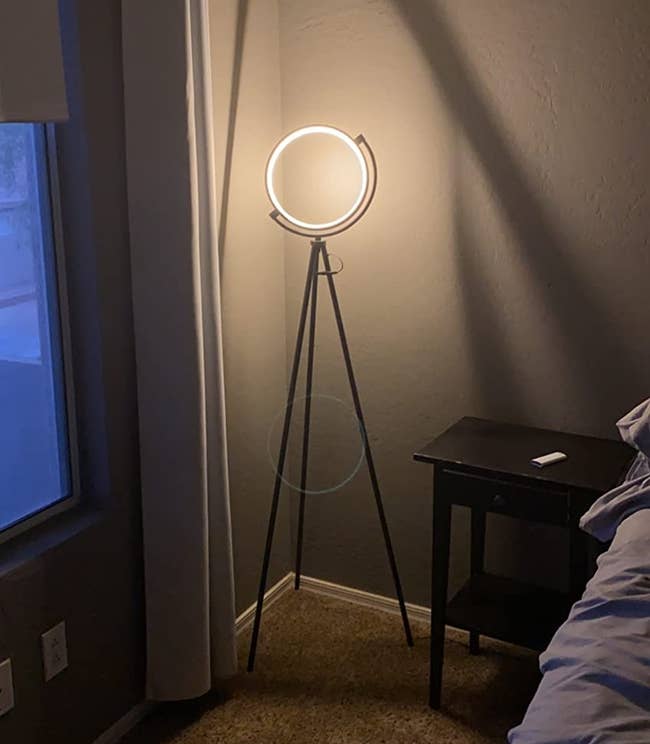 Reviewer image of black tripod modern floor lamp with open circular light next to black side table