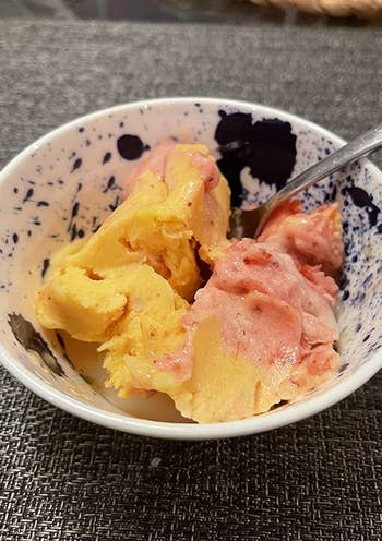 A close up of a reviewer's yellow and red sorbet 