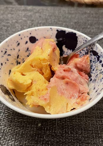 A close up of a reviewer's yellow and red sorbet 
