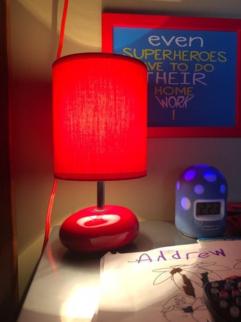 reviewer photo of red lamp with red shade on child's nightstand