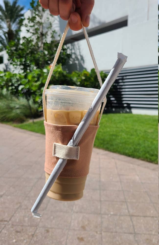 a model holding an ice coffee inside the cup carrier 