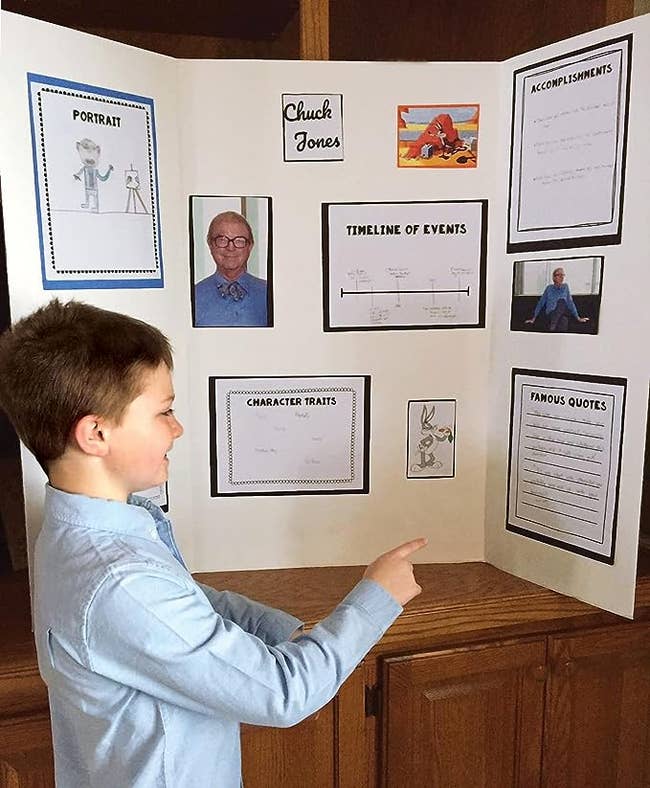 A child standing in front of the presentation board that has a project displayed on it