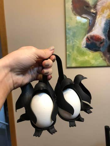 reviewer holding the egg holder made to look like penguins