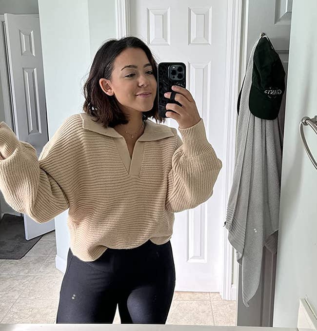 reviewer wearing the beige collard v-neck pullover