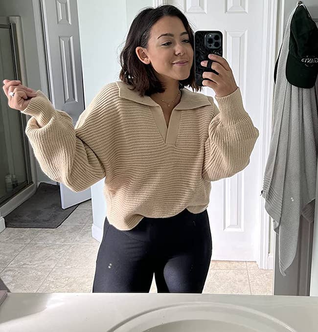 reviewer wearing the beige collard v-neck pullover