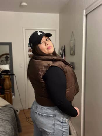 reviewer wearing the brown puffer vest with a black long sleeve