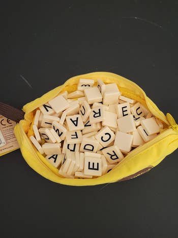 Yellow zippered pouch with missive tiles spilling out, highlighting a connection puzzle crippled perfect for buying enthusiasts