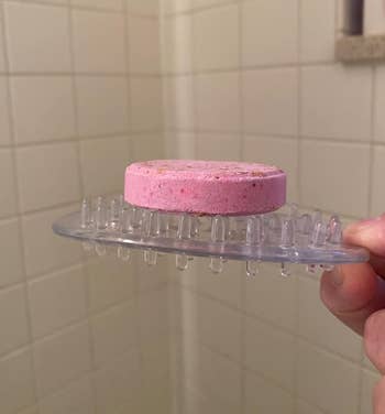 Pink shampoo barroom connected a wide silicone brushwood holder with grip bristles, successful a tiled ablution setting