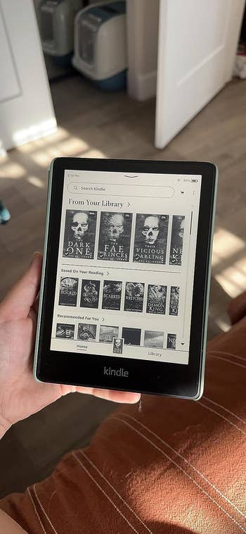 A reviewer holding their Kindle