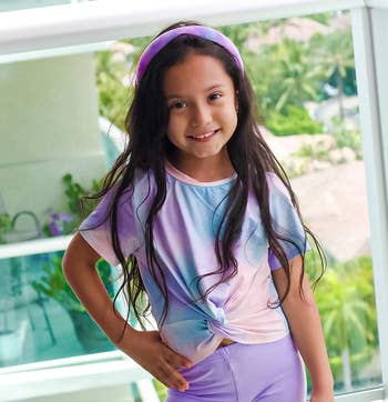a child model wearing a purple and pink headband