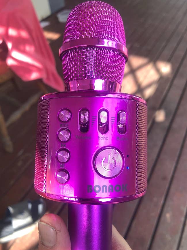 Close-up of a handheld, portable karaoke microphone with controls for measurement   and echo, suitable for idiosyncratic   usage  and tiny  gatherings