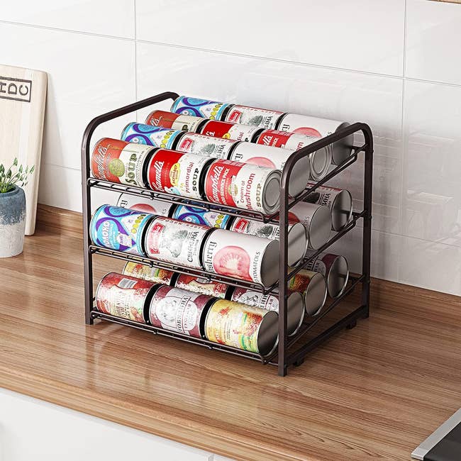 Two-tier metal can organizer with multiple cans on kitchen countertop