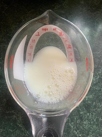 a reviewer's top down view showing a cup of milk being measured