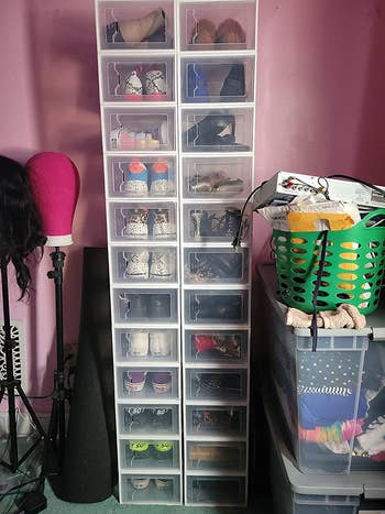 a reviewer photo of the drop front shoeboxes stacked in two columns in a bedroom 