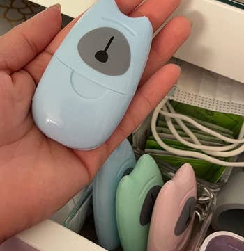 reviewer holding the blue bear-shaped soap sheet holder