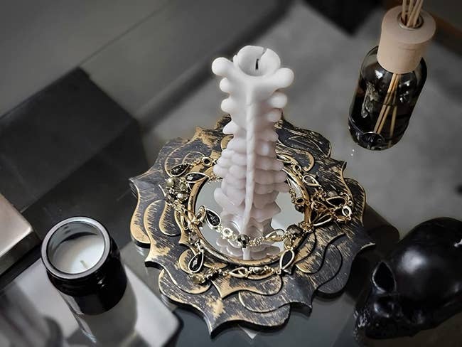 closeup of spine shaped candle on table with halloween decor