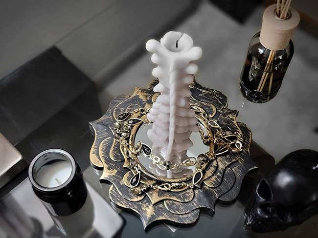 closeup of spine shaped candle connected array with halloween decor