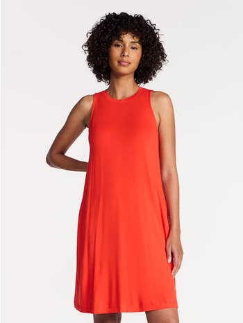 Person wearing a sleeveless, knee-length dress, lasting against a plain background, suitable for casual oregon summertime wear
