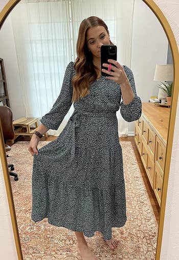 a reviewer wearing the long sleeve midi dress in blue with white dots 