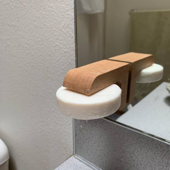 reviewer's magnetic soap holder holding a bar of white soap