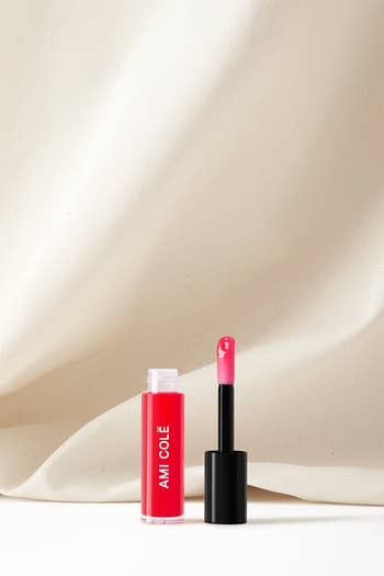 Lipstick and open tube with applicator, on a smooth surface, from Axiology Beauty, highlighting eco-friendly packaging