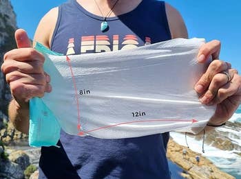 Person holding a package of extra large wipes with measurements displayed