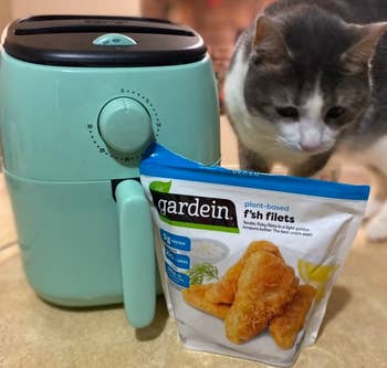 air fryer next to a cat and a bag of plant-based fish filets