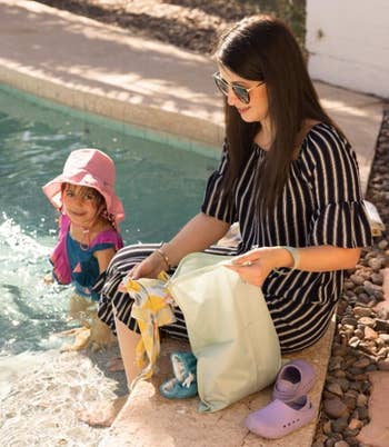 a model and a child in a pool putting stuff in the wet bags