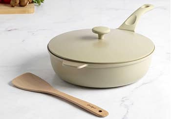 the beige pan and wooden spoon