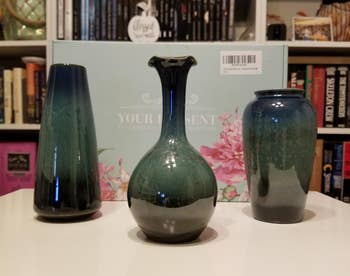 Reviewer image of three blue and green different shaped ombré vases in front of product box on top of white table