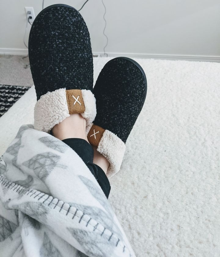 reviewer wearing the black anti-slip slippers