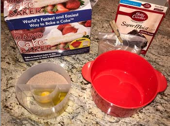Reviewer showing the red cake maker bowl next to a transparent bowl with room for cake mix, oil, and an egg 