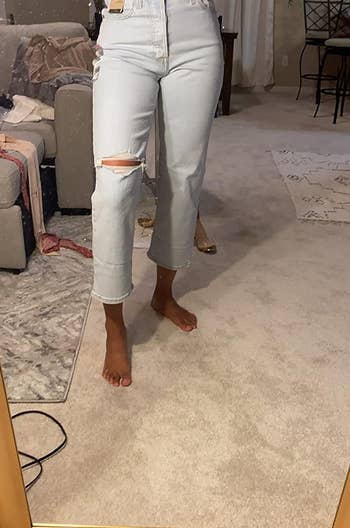 reviewer showing off the front of the high rise jeans in shade space ripple