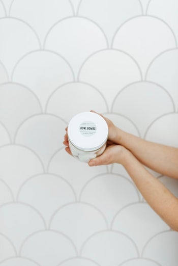 Model holding the jar of toilet bombs