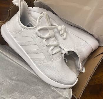 reviewer photo of the white sneakers in a shoe box