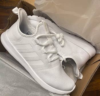reviewer photo of the white sneakers in a shoe box