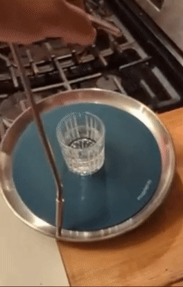 reviewer picking up tray one handed and swirling it around to show the water in a cup on it won't spill