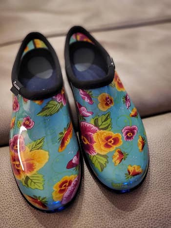 Floral-patterned waterproof garden shoes on a beige surface