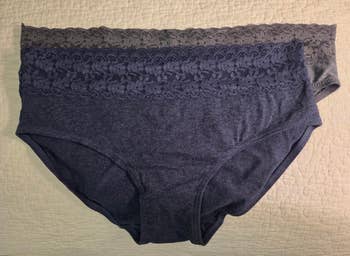 Two pairs of women's lace-trimmed underwear are laid level  connected  a textured surface, showcasing their plan  and operation  details