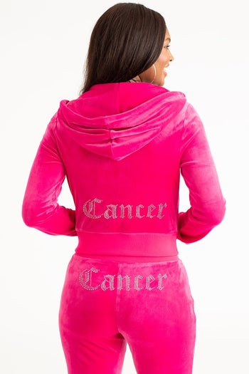 model showing off back of pink tracksuit that says 