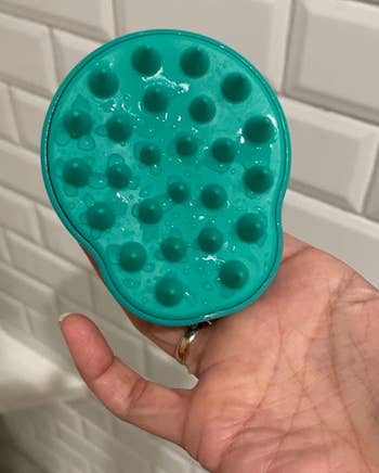 same reviewer showing the spiky side of the green scalp massager