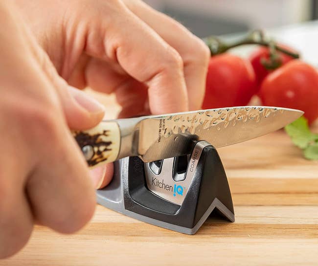 model sharpening a knife using the sharpener