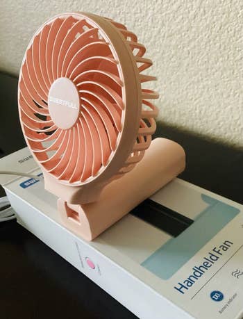 Compact handheld instrumentality connected a box; portable and battery-powered plan perfect for on-the-go cooling