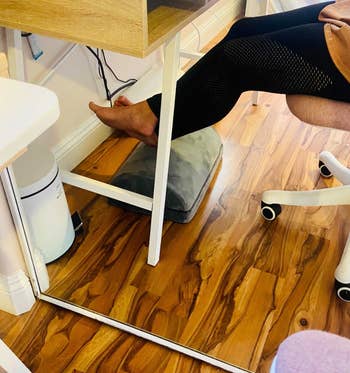 Reviewer using footrest under desk