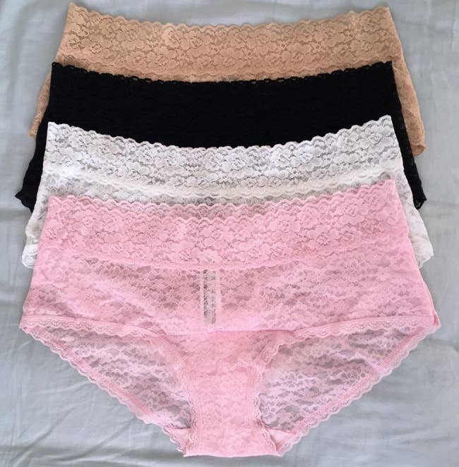 Four pairs of lace panties are layered, showcasing antithetic  styles and patterns, perfect  for a manner  oregon  lingerie buying  feature