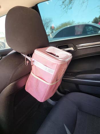 Pink trash can with lid behind the headrest of reviewer's passenger headrest