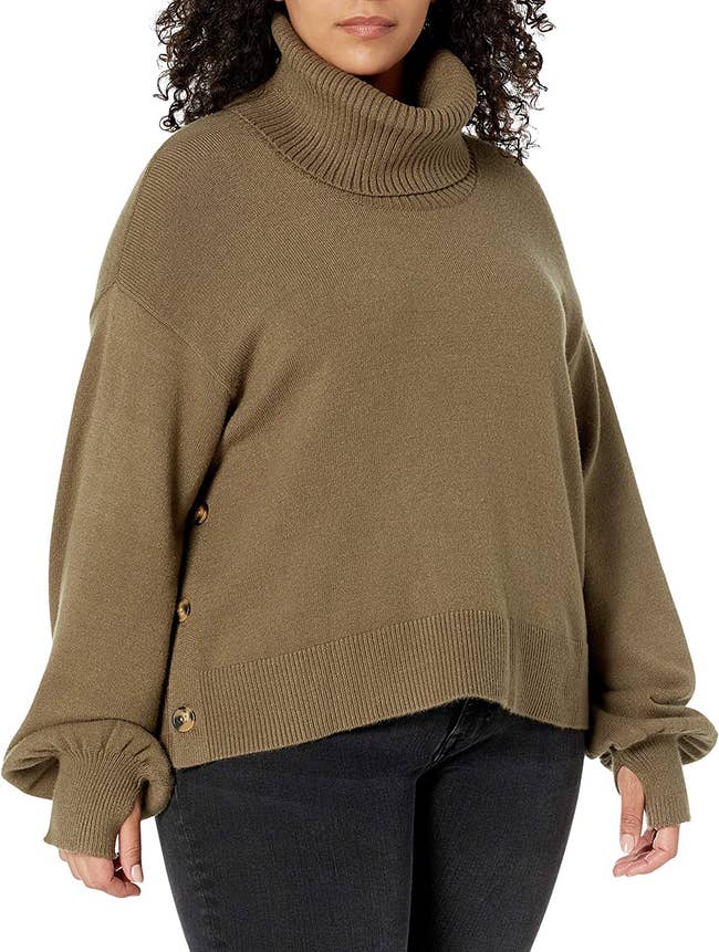a plus size model wearing the olive colored sweater